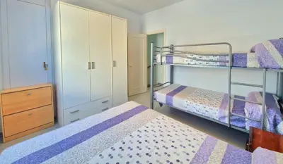 a bedroom with two bunk beds and a dresser at La almadraba in Chiclana de la Frontera