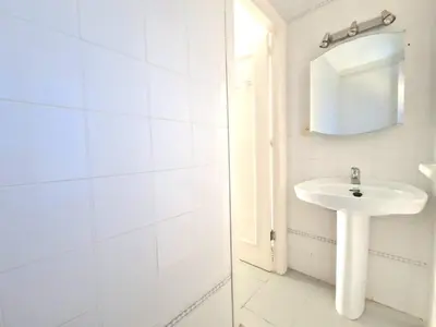 a white bathroom with a sink and a mirror at La almadraba in Chiclana de la Frontera