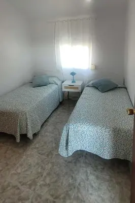 a bedroom with two beds and a table with a window at Casa La Retama in La Barca de la Florida