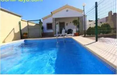 a large blue swimming pool in front of a house at Casa rural 1 in Conil de la Frontera