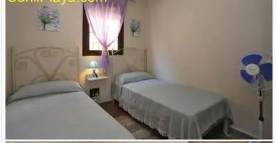 a bedroom with two beds and a window at Casa rural 1 in Conil de la Frontera