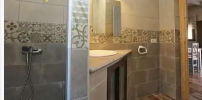 a bathroom with a sink and a shower with a mirror at Casa rural 1 in Conil de la Frontera