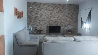 a living room with a couch and two chairs and a tv at Casa rural 1 in Conil de la Frontera