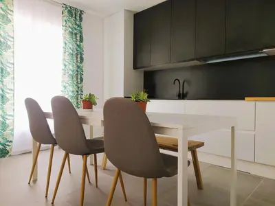 a kitchen with a white table and chairs at Apartamentos Muñoz Fornell 2 in Chiclana de la Frontera