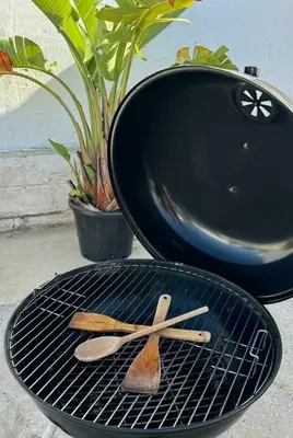 a grill with two wooden spatulas and a grill at Apartamentos Muñoz Fornell 2 in Chiclana de la Frontera
