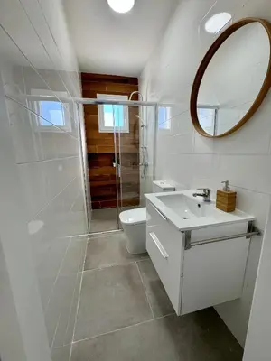 a white bathroom with a toilet and a mirror at Apartamentos Muñoz Fornell 2 in Chiclana de la Frontera