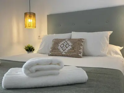 a bed with a white towel on top of it at Apartamentos Muñoz Fornell 1 in Chiclana de la Frontera