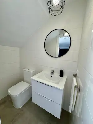 a white bathroom with a toilet and a mirror at Apartamentos Muñoz Fornell 1 in Chiclana de la Frontera