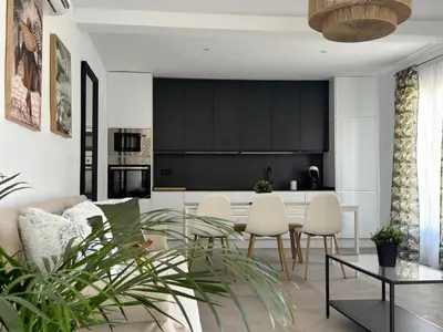 a kitchen and living room with a table and chairs at Apartamentos Muñoz Fornell 1 in Chiclana de la Frontera