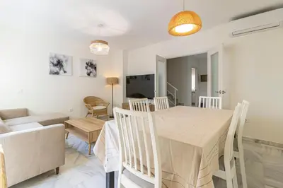 a dining room and living room with a table and chairs at Allo Apartments Medina Duplex Parking 3 Habitaciones in Jerez de la Frontera