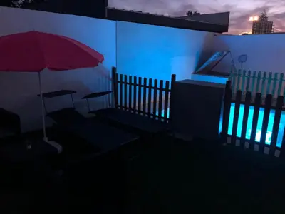 a room with a fence and a red umbrella at Vivienda con piscina Jacuzzi in Chiclana de la Frontera
