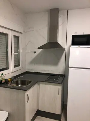 a small kitchen with a sink and a refrigerator at Vivienda con piscina Jacuzzi in Chiclana de la Frontera