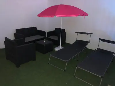 a living room with a couch and a red umbrella at Vivienda con piscina Jacuzzi in Chiclana de la Frontera
