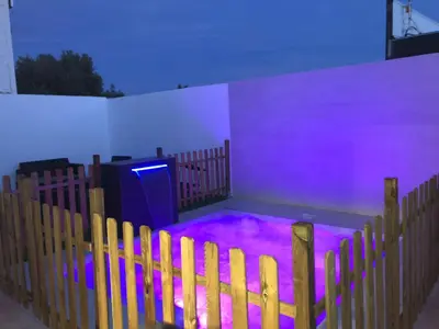 a room with purple lights in a room with a fence at Vivienda con piscina Jacuzzi in Chiclana de la Frontera
