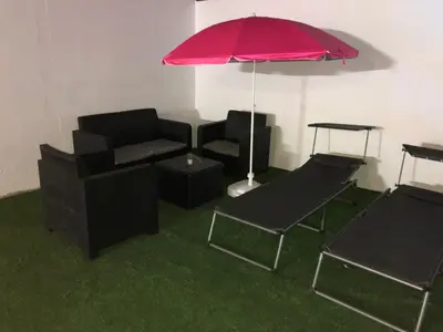 a living room with a couch and an umbrella at Vivienda con piscina Jacuzzi in Chiclana de la Frontera