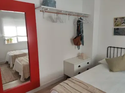 a bedroom with a mirror and a bed at Casa Bakio in Sanlúcar de Barrameda