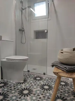 a bathroom with a toilet and a glass shower at Casa Bakio in Sanlúcar de Barrameda