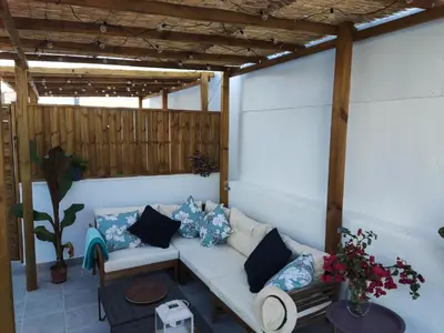 a living room with a white couch and blue pillows at Casa Bakio in Sanlúcar de Barrameda