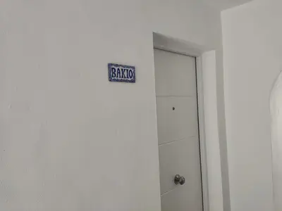 a bathroom with a sign that says baths on the wall at Casa Bakio in Sanlúcar de Barrameda