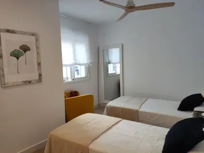a bedroom with two beds and a ceiling fan at Casa Laida in Sanlúcar de Barrameda