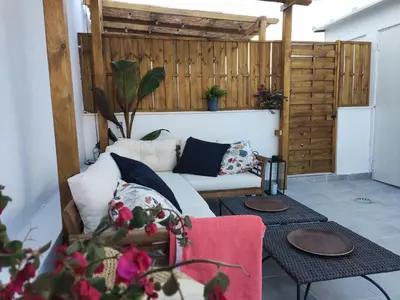 a living room with a white couch and two tables at Casa Laida in Sanlúcar de Barrameda