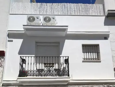 a white building with two air conditioners on a balcony at Casa Laida in Sanlúcar de Barrameda