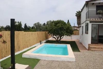 a swimming pool in a yard next to a fence at Casa Abuelo Miguel in Conil de la Frontera
