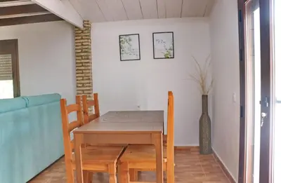 a dining room with a table and chairs and a vase at Casa Abuelo Miguel in Conil de la Frontera