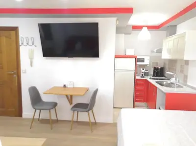 a kitchen with a table and chairs and a tv on the wall at Acogedor Apartamento Entero in Arcos de la Frontera
