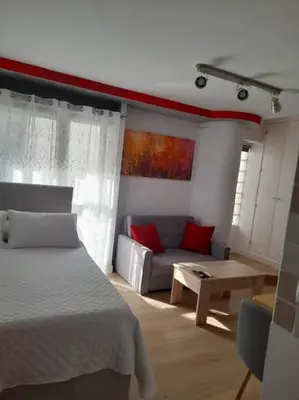 a bedroom with a bed and a couch and a table at Acogedor Apartamento Entero in Arcos de la Frontera