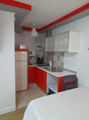 a kitchen with red and white cabinets and a sink at Acogedor Apartamento Entero in Arcos de la Frontera
