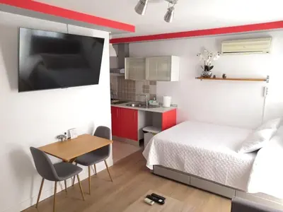 a bedroom with a bed and a table and a kitchen at Acogedor Apartamento Entero in Arcos de la Frontera