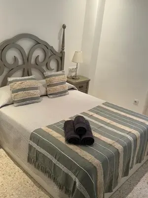 a bed with a pair of slippers sitting on it at Lola9 in Sanlúcar de Barrameda