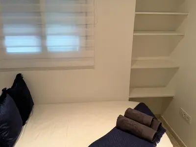 a small bedroom with a bed and a window at Lola9 in Sanlúcar de Barrameda
