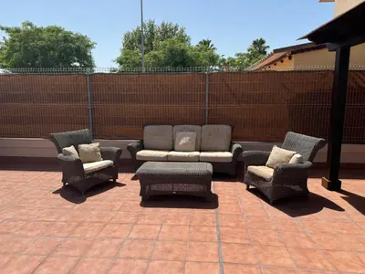 a patio with four chairs and a couch and a table at Lola9 in Sanlúcar de Barrameda