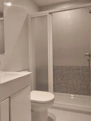 a white bathroom with a toilet and a shower at Lola9 in Sanlúcar de Barrameda