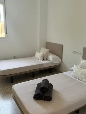 two beds in a room with towels on them at Lola9 in Sanlúcar de Barrameda