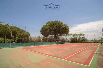 a tennis court with a net on top of it at Apartamento los jardines in Sanlúcar de Barrameda