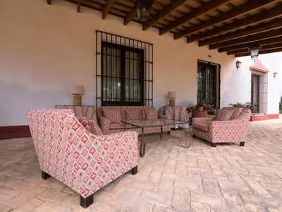a patio with couches and a table and windows at Casa Rancho el Marques fjhomefj in Jerez de la Frontera