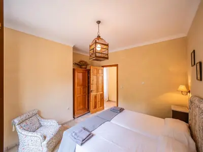 a bedroom with a white bed and two chairs at Casa Rancho el Marques fjhomefj in Jerez de la Frontera