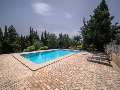 a swimming pool with two chairs and a bench at Casa Rancho el Marques fjhomefj in Jerez de la Frontera