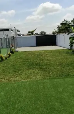 a yard with a white fence and green grass at Finca Rural Marmito in Sanlúcar de Barrameda