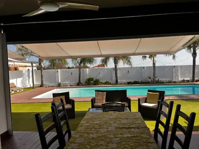 a patio with a table and chairs and a swimming pool at Finca Rural Marmito in Sanlúcar de Barrameda