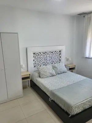 a white bedroom with a bed and a mirror at Casa Andrea in Puerto Real