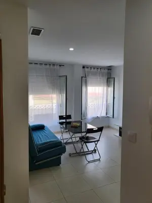a living room with a couch and a table and chairs at Casa Andrea in Puerto Real