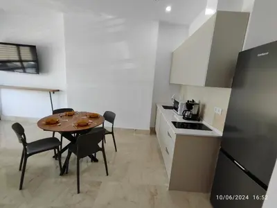 a small kitchen with a table and chairs in a room at Apartamentos Luxury Play Victoria in Cádiz