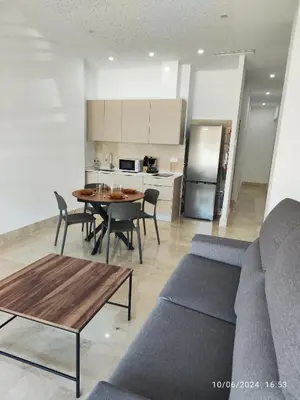 a living room with a couch and a table and a kitchen at Apartamentos Luxury Play Victoria in Cádiz