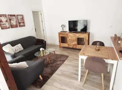 a living room with a couch and a table and a tv at Apartamento 'Mini Jungle' en el corazón de Cádiz in Cádiz