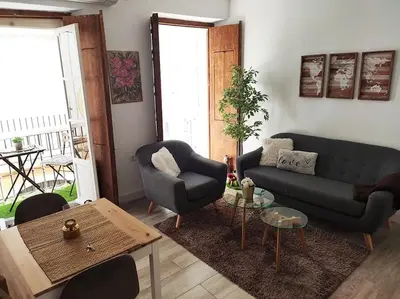 a living room with a couch and a chair and a table at Apartamento 'Mini Jungle' en el corazón de Cádiz in Cádiz
