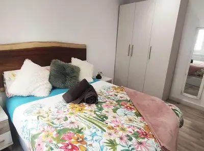 a bedroom with a bed with a floral bedspread at Apartamento 'Mini Jungle' en el corazón de Cádiz in Cádiz